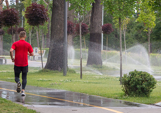 Man Running on Sidewalk by Lawn with a Lawn Sprinkler System in Brighton, Broomfield, Erie, Thornton, Westminster